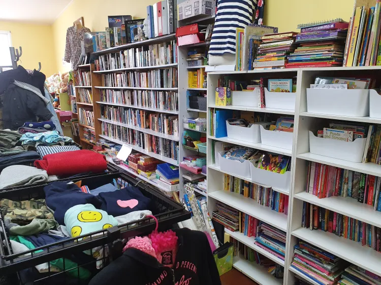 Shelves of donated books, DVDs and children's items inside the Concord Op Shop